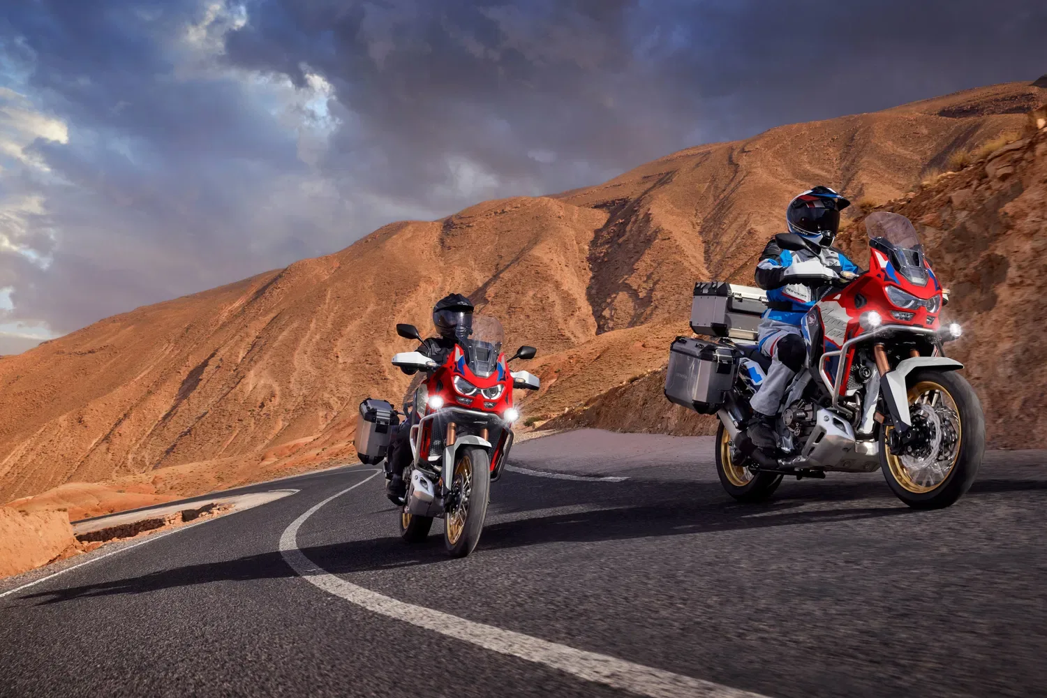 Two Honda Africa Twin adventure motorcycles on a mountain pass